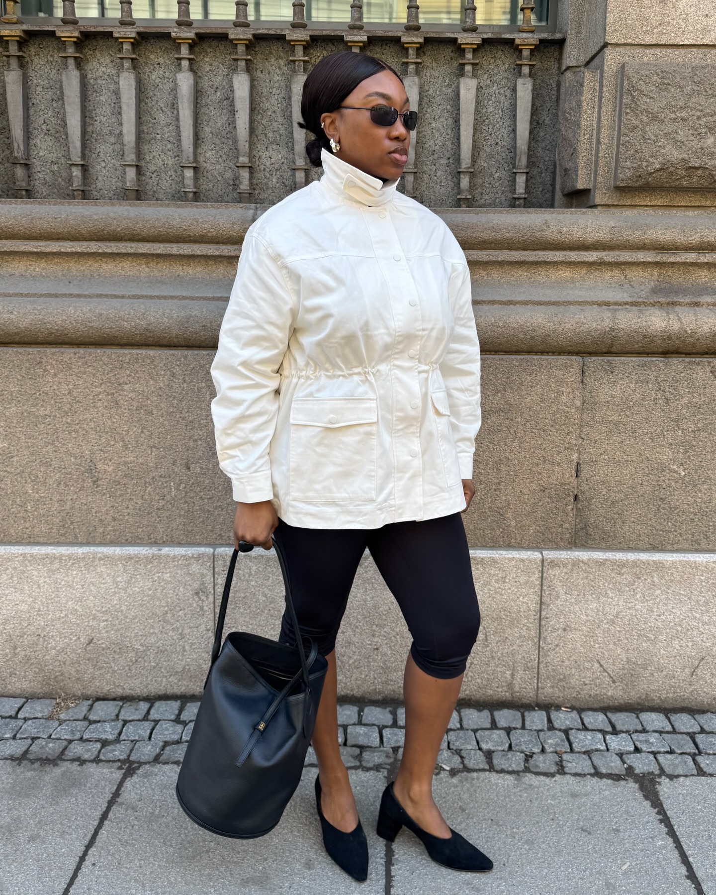 nnenna echem wears a funnel neck jacket, capri trousers, glove heels and a bucket bag