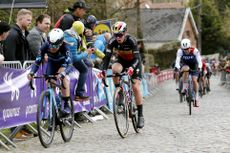 Annemiek van Vleuten and Lotte Kopecky ride bikes on cobbles at the Tour of Flanders 2022
