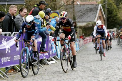 Annemiek van Vleuten and Lotte Kopecky ride bikes on cobbles at the Tour of Flanders 2022