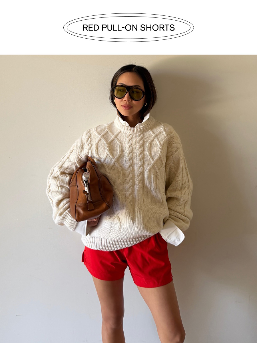 Influencer wearing red shorts with a cableknit sweater