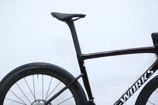 A red Specialized S-Works Tarmac SL8 stands against a white wall