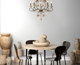 Wooden trinkets arranged on round dining room with black chairs