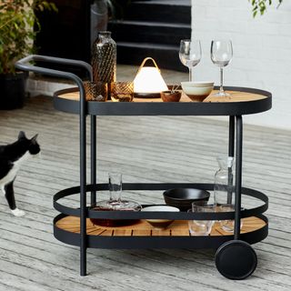 Wooden and black steel drinks trolley with glassware