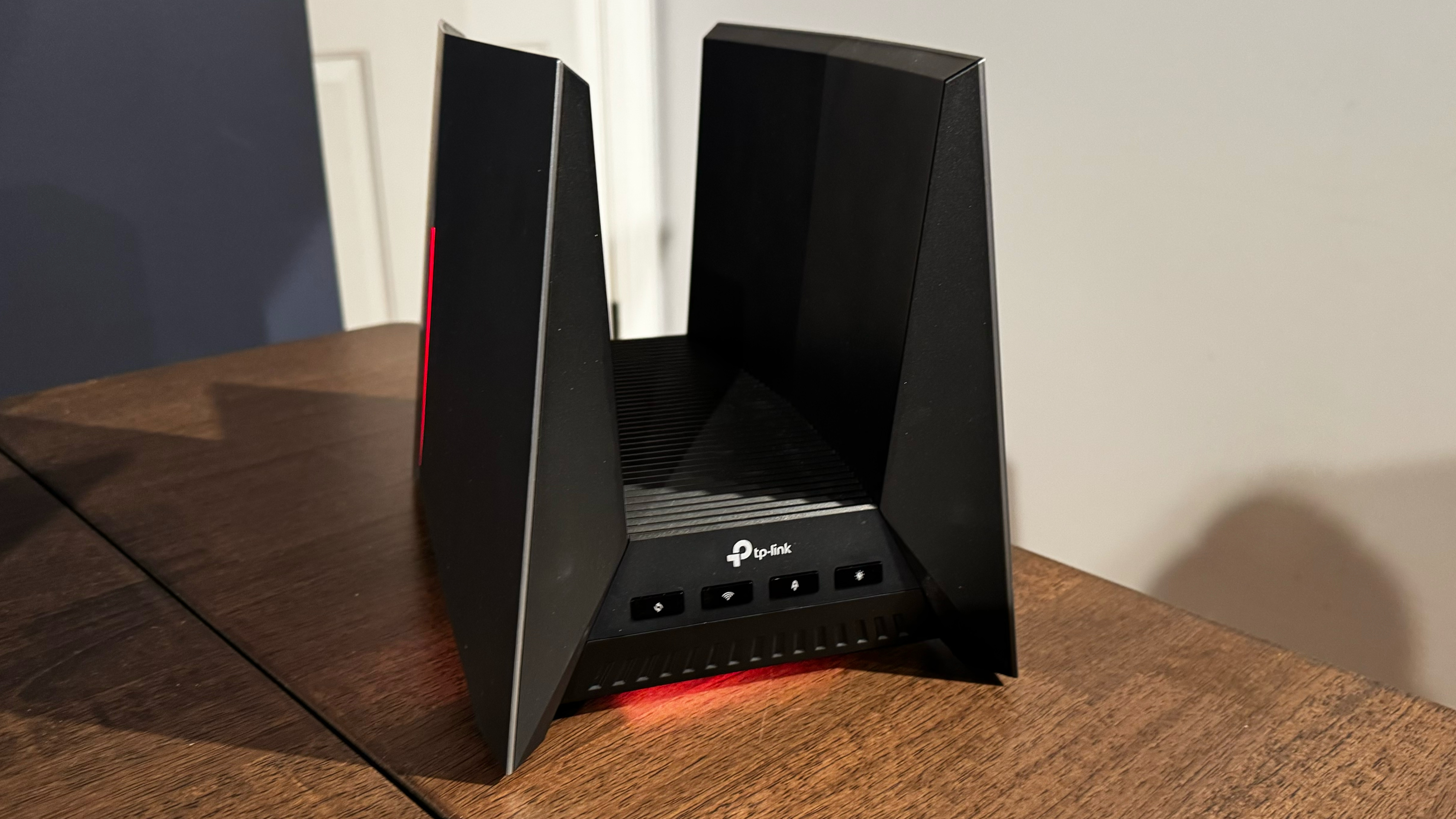 The TP-Link Archer GE800 powered on, and on a desk.