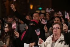 Immigrants wave American flags.