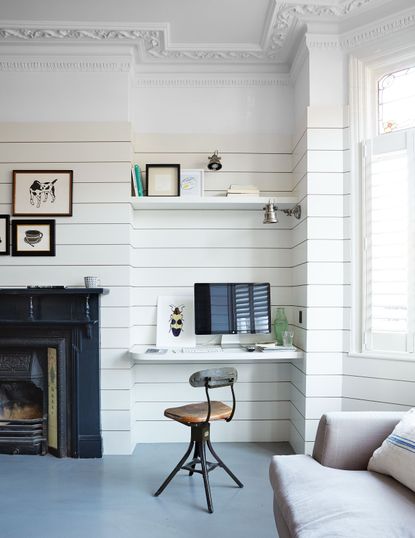 a stylish desk in a white paneled room