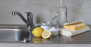 Stainless steel sink with lemon and baking soda to show how to clean a stainless steel sink with natural cleaning products