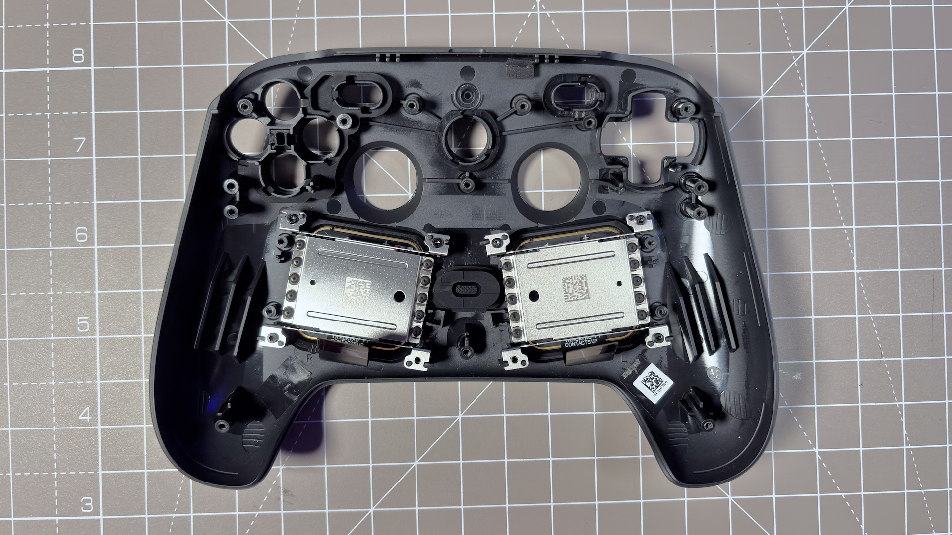 The Steam Controller on a desk during a teardown, with various parts removed.
