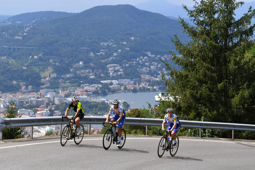 Three cyclists climbing mountain