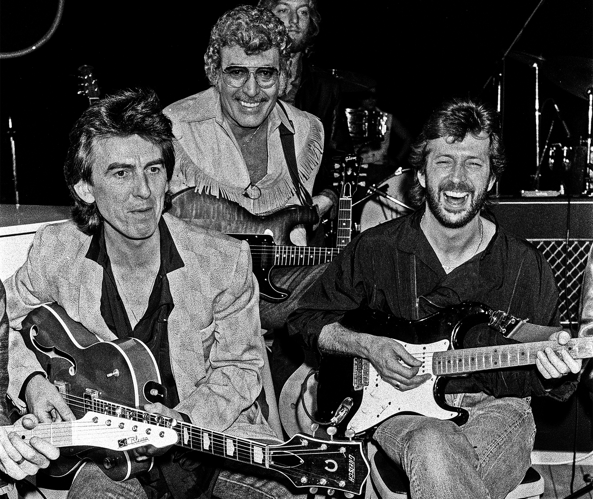 Carl Perkins assembled himself a super backing group at Channel 4's Limehouse Studios for a television programme 'Blue Suede Shoes'. Left to right: Beatles guitarist George Harrison with Carl Perkins and Eric Clapton. 21st October 1985.