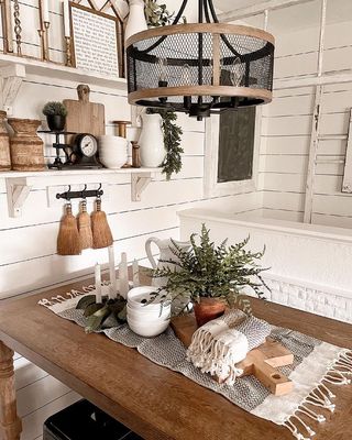 White kitchen with wooden table and wall paneling