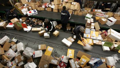 OAKLAND, CA - DECEMBER 18:FedEx worker sort through a pile of boxes at the FedEx sort facility at the Oakland International Airport December 18, 2006 in Oakland, California. Days before Chris