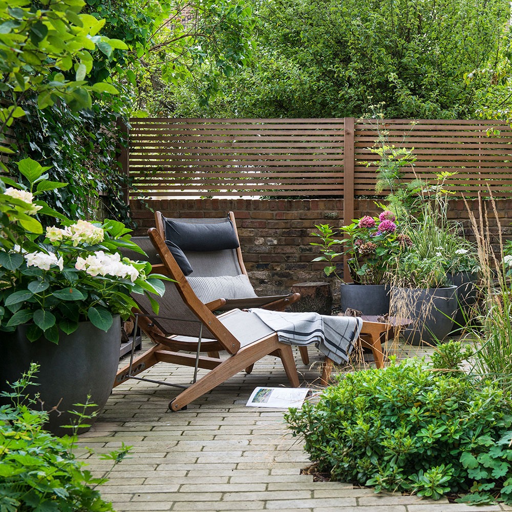 garden area with wooden fence and lounge chairs