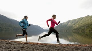 Two women jogging together along the shore of Lake Crescent in Olympic NP
