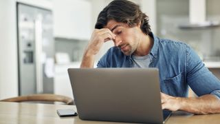 Man stressed out using laptop.