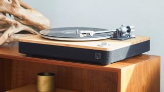 Best budget turntables image show the House Of Marley Stir It Up turntable photographed on a wooden table in a room with light blue walls