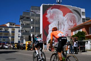 OUREM PORTUGAL AUGUST 18 LR Ibon Ruiz of Spain and Team Equipo Kern Pharma and Luis Angel Mate of Spain and Team Euskaltel Euskadi compete in the breakaway passing a wall mural during the 79th La Vuelta Ciclista a Espana 2024 Stage 2 a 194km stage from Cascais to Ourem UCIWT on August 18 2024 in Ourem Portugal Photo by Tim de WaeleGetty Images