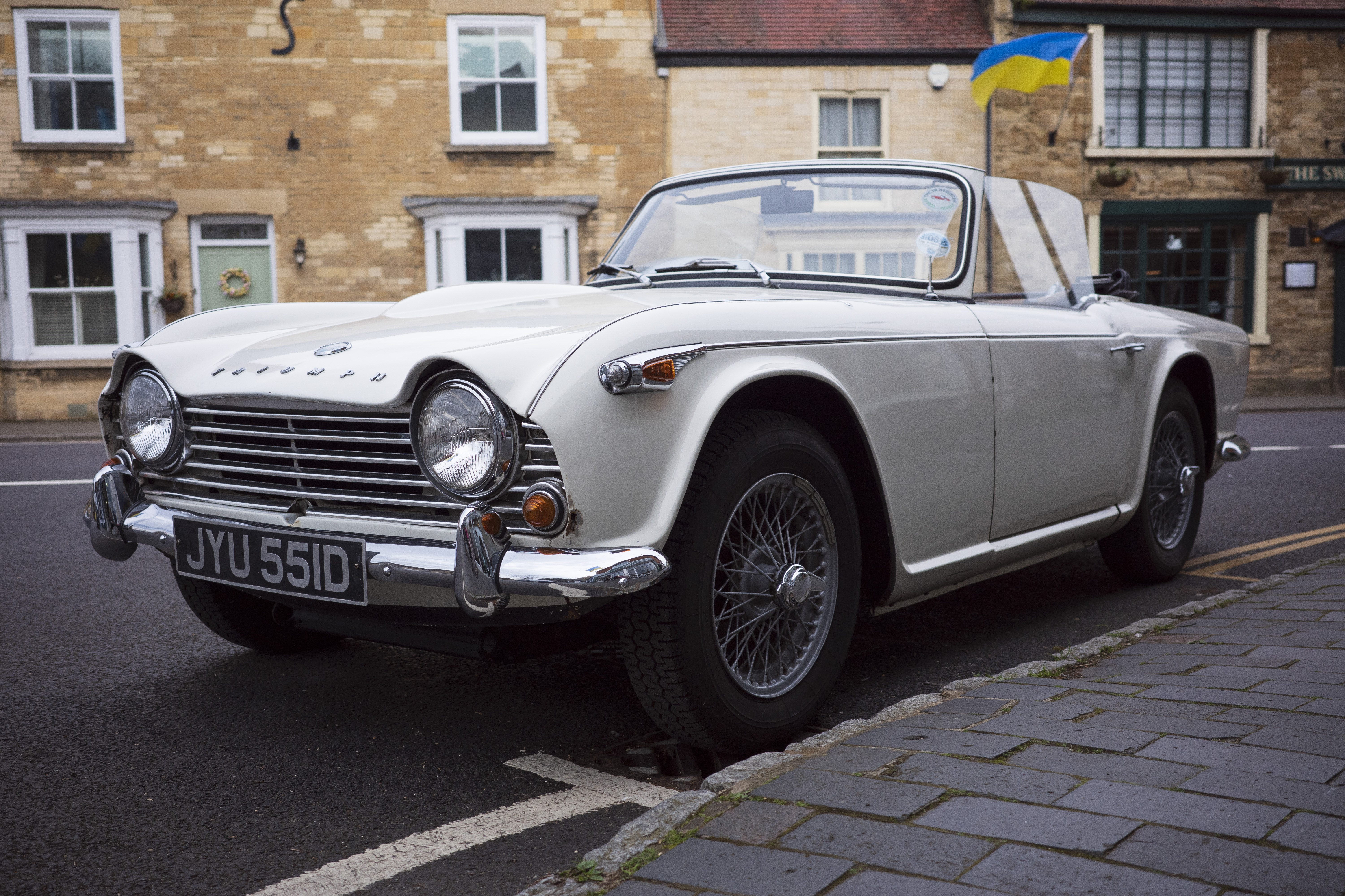 A white motor car parked on a street