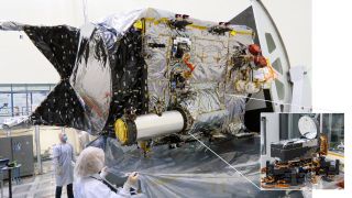 A satellite sits in a clean room.