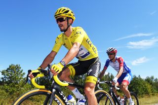 Julian Alaphilippe riding his bike wearing the Tour de France yellow jersey