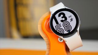 Un Samsung Galaxy Watch 4 mostrando un reloj digital y una figura corriendo con el letrero "¡GO!"