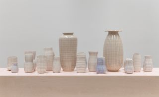 Along a plywood runway topped with pink Formica, Kusaka investigates her geometric abstractions on super-sized vessels that curve around a corner toward the delicate pairing of a stovepiped stoneware pot and a white gourd-like Cypriot form.