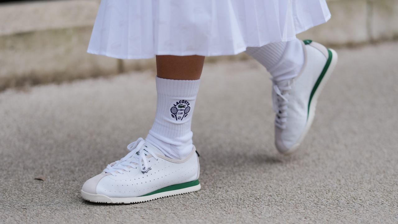 A guest wears white socks, white sneaker shoes, outside Lacoste, during the Paris Fashion week Women&#039;s Fall/Winter 2025-2026 on March 9, 2025 in Paris, France. 