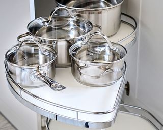 a swivel corner kitchen cupboard with steel saucepans, to show one of w&h's pan storage ideas