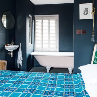 master bedroom with deep blue walls and bathtub