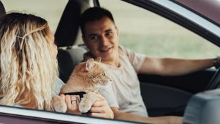 Couple in car with cat