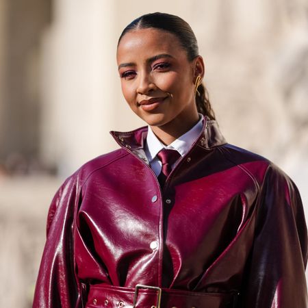 street style shot of woman wearing red leather jacket with long lashes