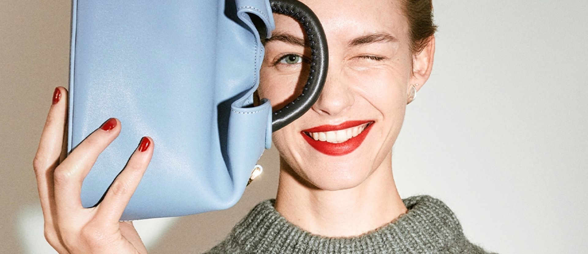 Woman with blue bag over half her face