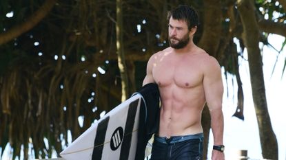Liam Hemsworth looks in great shape as he goes for a surf