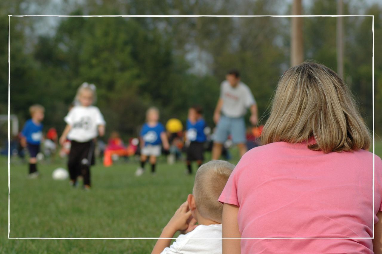 Football mum sitting on the sidelines watching her child play football