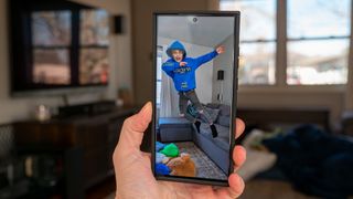 Taking a photo on a Samsung Galaxy S23 Ultra of a child jumping off a couch