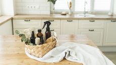 A set of natural cleaning supplies in a basket on a kitchen kitchen island