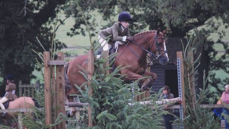 Susie Eddis and Beat The Boss jump a rustic spread at the Royal International