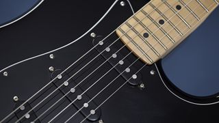 Close of of pickups on a black Fender Stratocaster