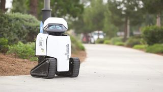 The Daxbot sits cutely on a sidewalk