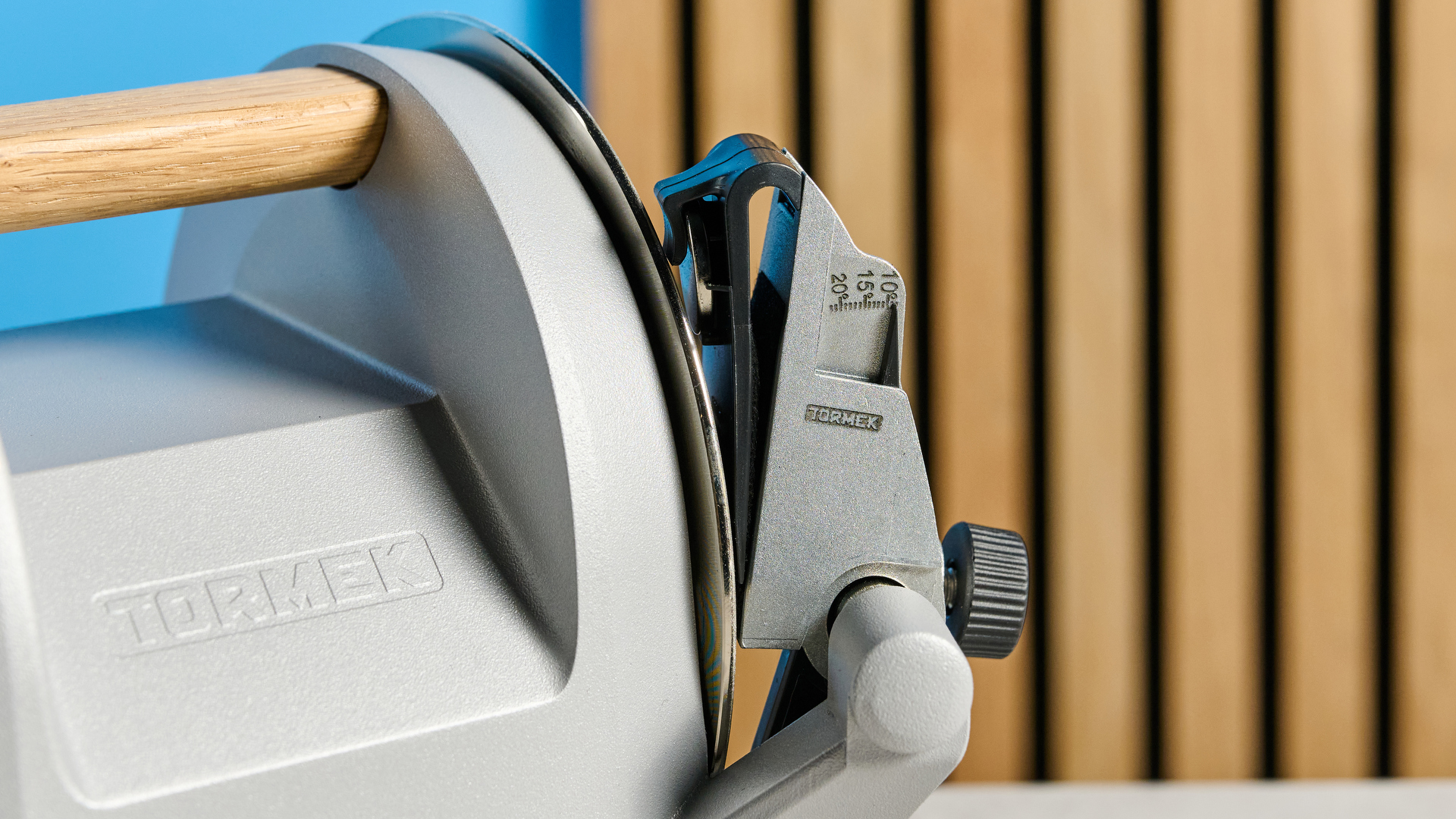 Tormek T-1 knife sharpener on a stone surface with a blue background