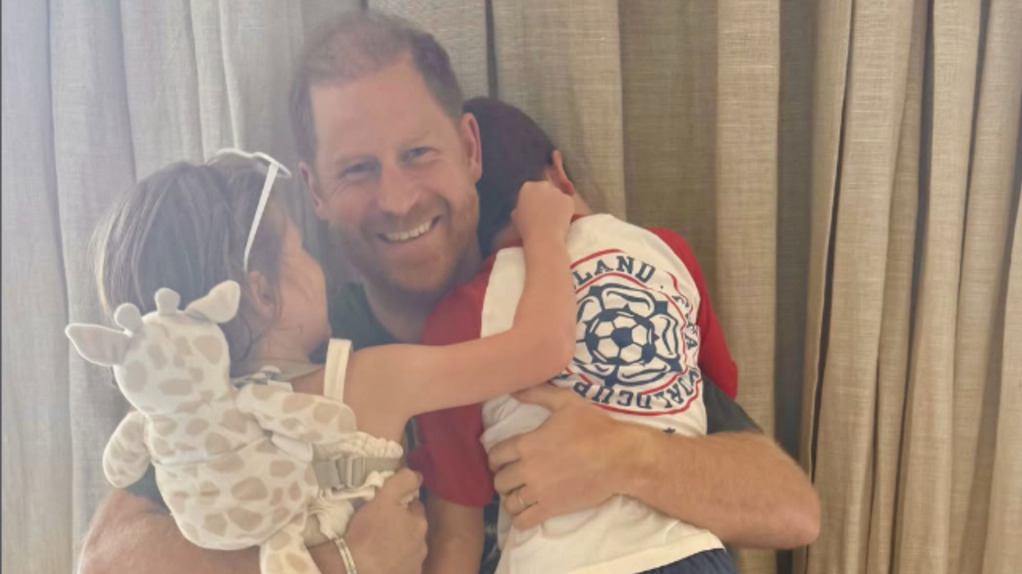 A screenshot of Meghan Markle's Instagram post for Father's Day, featuring Prince Harry hugging Archie and Lilibet