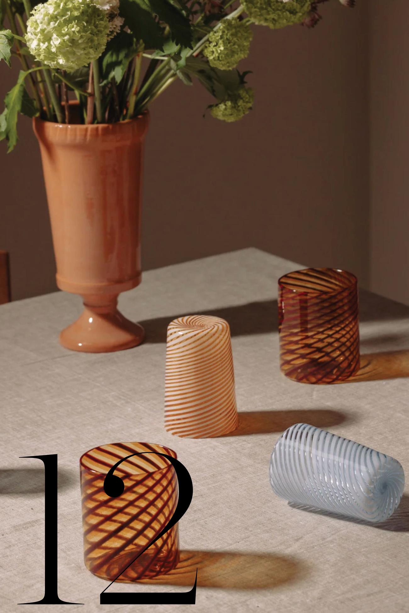 table set with murano glass tumblers and vase with flowers