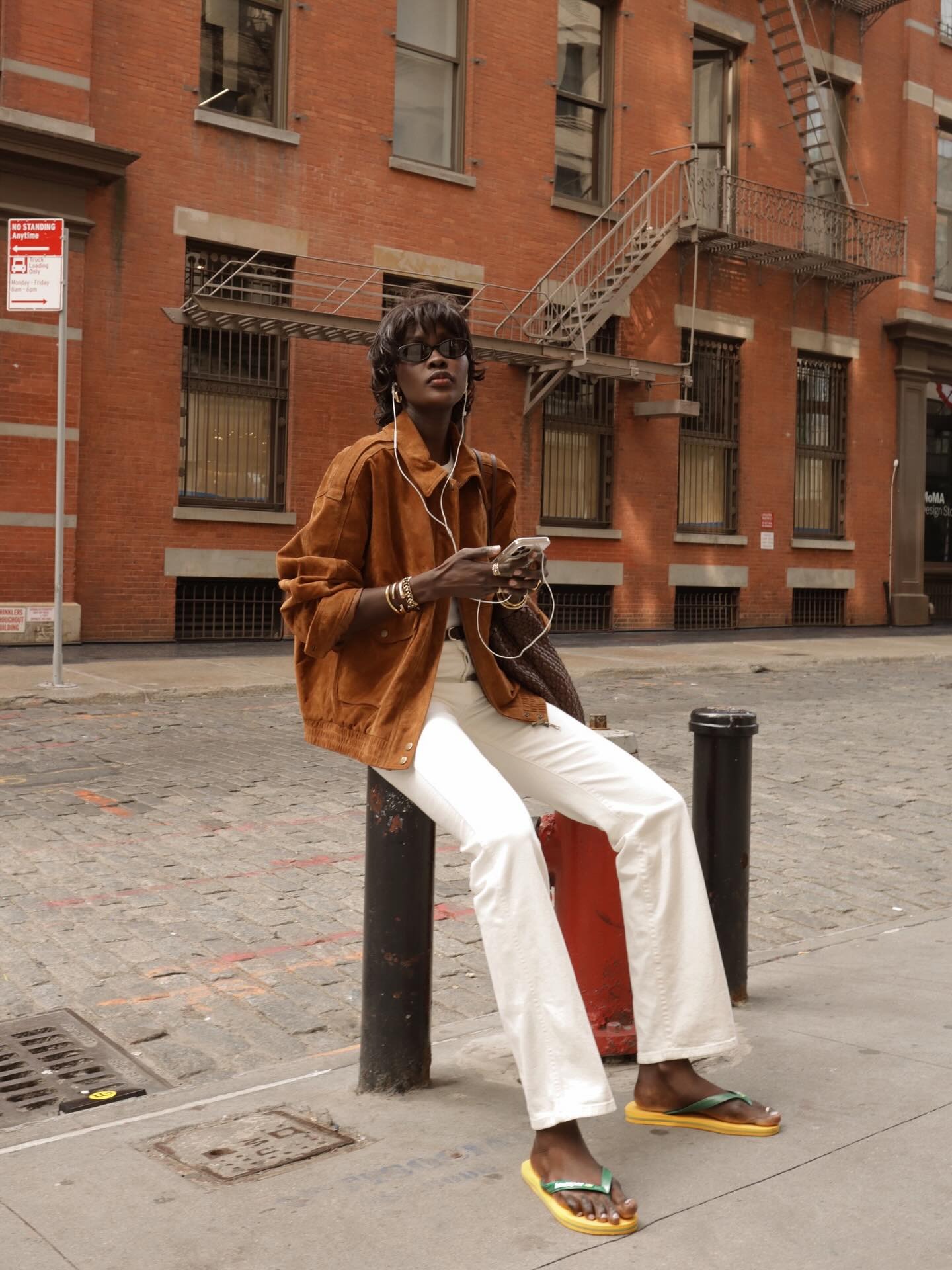 Fashion Person Amy Lefevre shows you how to style white jeans. She wears a brown suede bomber, a white top, a black belt, white jeans and the Barizl Havianas. She&#039;s sat looking at the camera in front of a red brick New York apartment in a recent image taken from her Instagram.