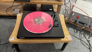 Rekkord Audio F110 turntable on wooden rack with pink vinyl record