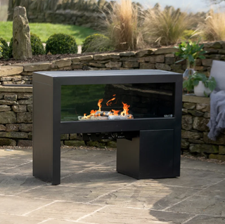 Black freestanding outdoor fireplace on tiles