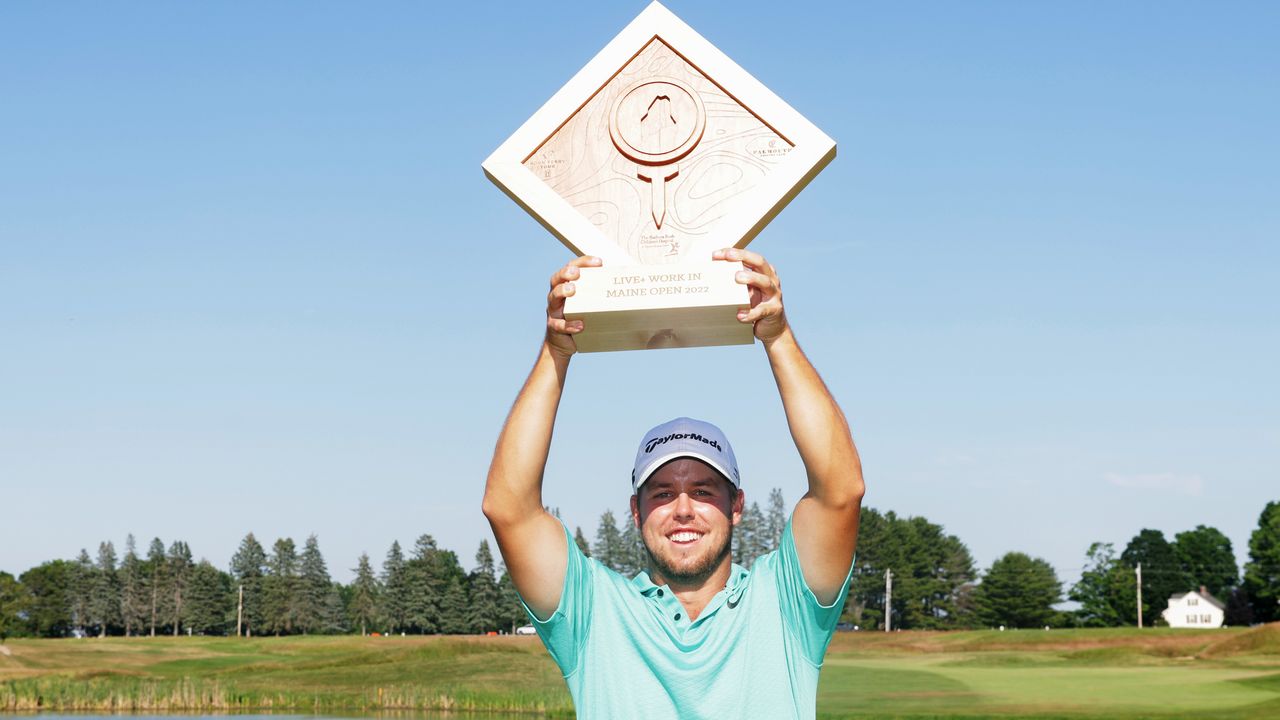 Pierceson Coody holds a trophy above his head