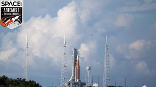 nasa space launch system giant rocket on launch pad with clouds in background sky