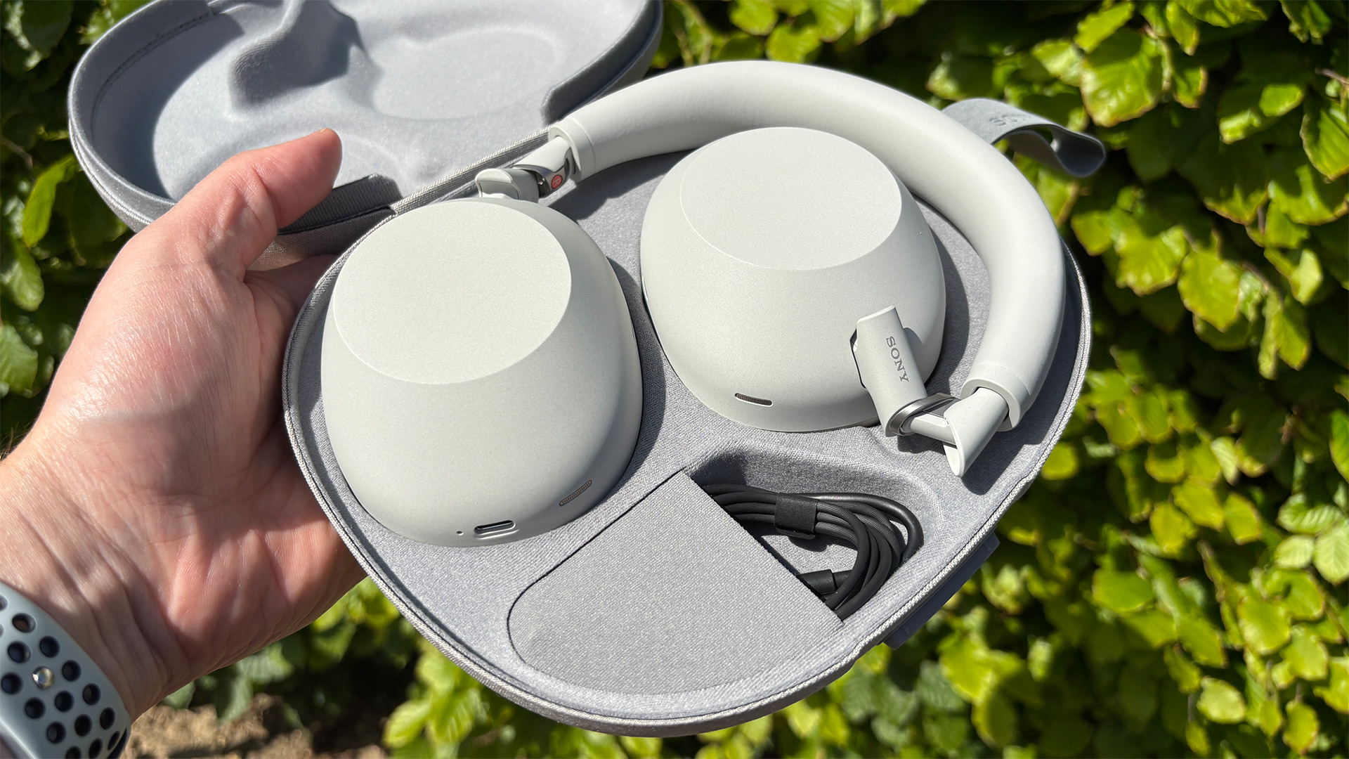 Sony WH-1000XM6 over-ear headphones in carry case held in hand