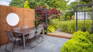 Japanese style garden designed by Sara Jane Rothwell Garden Design, with different paved zones including a garden table and chairs, and a decking