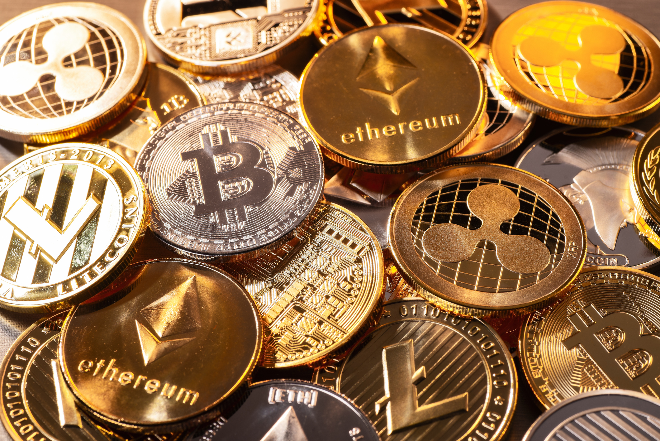Coins of various cryptocurrencies including Bitcoin and Ethereum